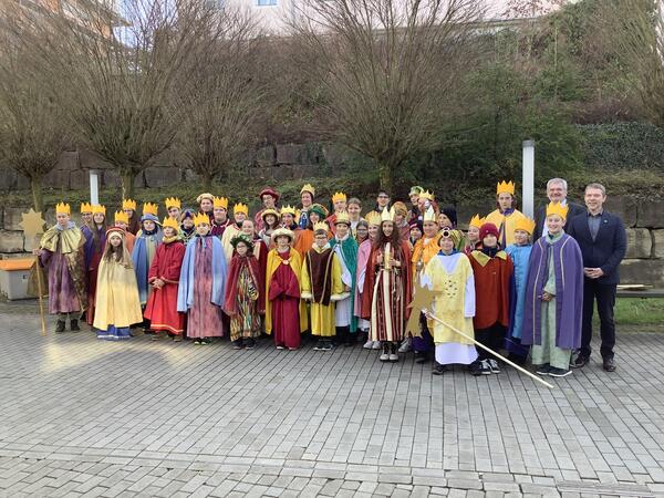 Bild vergrößern: Viele Kinder die als Sternsinger verkleidet sind. Zwei Erwachsene, Herr Pfarrer Christian Kalis und Herr Bürgermeister Andreas Wopperer.