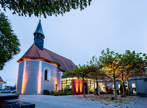 Bild vergrößern: Foto der beleuchteten Spitalkirche in der Dämmerung