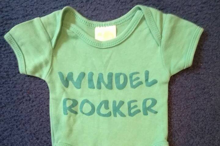 Ein grner Baby-Body mit der Aufschrift "Windelrocker"