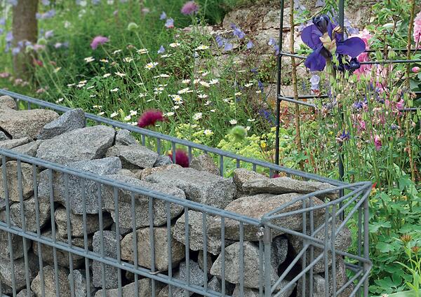Eine Steinmauer auf einer bunten Wiese