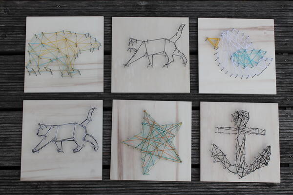 sechs verschiedene Bilder aus Nägeln, die mit Fäden umwickelt werden und so ein Motiv ergeben. Zu sehen sind zwei Katzen, ein Bär, ein Stern und ein Anker. 