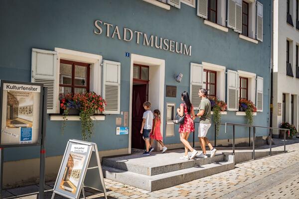 Eine Familie geht in das Stadtmuseum