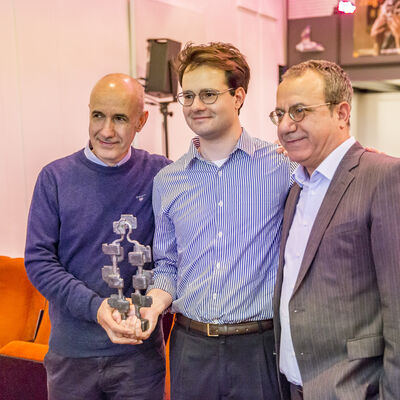 Die drei Gewinner des Bayerischen Dokumentarfilmpreises, Daniel Asadi Faezi, sein Vater und sein Onkel halten den Pokal in die Kamera.