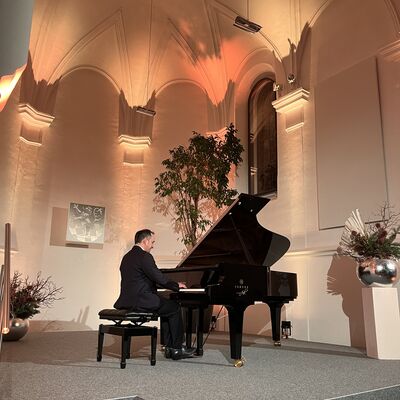 Der Pianist Christian Seibert sitzt auf der Bhne der Spitalkirche an einem offenen schwarzen Flgel.