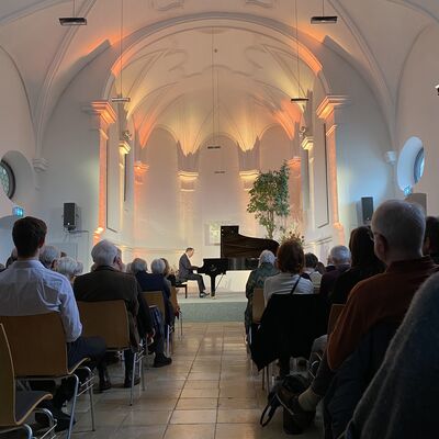 Der Pianist Christian Seibert sitzt auf der Bhne der Spitalkirche an einem offenen schwarzen Flgel.