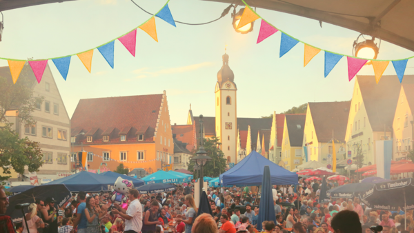 Bild vergrößern: Blick von der Bühne auf den mit Menschen gefüllten Schwandorfer Marktplatz. Im Hintergrund ist die Jakob-Kirche zu sehen.