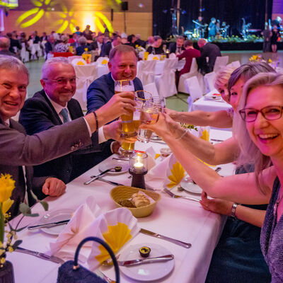 Foto von sechs lachenden Ballbesuchern, die mit ihren Gläsern anstoßen