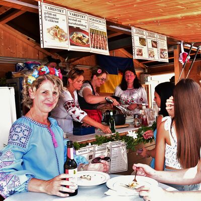 Bild vergrößern: Frauen in ukrainischer Tracht verkaufen traditionelle Gerichte aus ihrem Stand beim Schwandorfer Bürgerfest