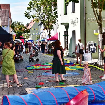 Bild vergrößern: Kinder spielen mit bunten Spielgeräten beim Bürgerfest Schwandorf in der Breite Straße.