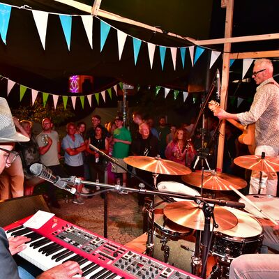 Bild vergrößern: Die Band "Rattle Gang" spielt auf der mit Fähnchen geschmückten Bühne am Blasturm.