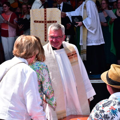 Bild vergrößern: Der Schwandorfer Stadtpfarrer Christian Kalis unterhlt sich vor der Bhne mit Besuchern des Brgerfestgottesdienstes.