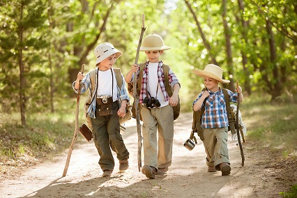 drei kleine Kinder gehen im Wald spazieren
