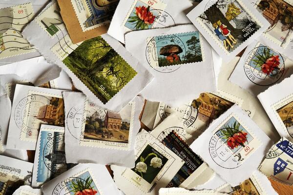 Bild vergrößern: verschiedene abgestempelte Briefmarken liegen übereinander.