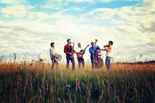 Bandfoto der 5 Bandmitglieder in einem Feld