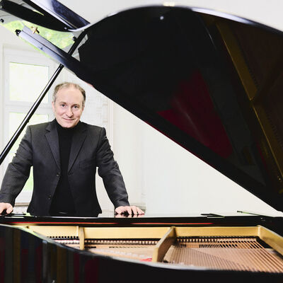 Bild vergrößern: Der Pianist Christian Seibert steht vor einem geöffneten schwarzen Flügel