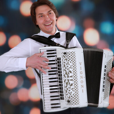 Bild vergrößern: Der Musiker Igor Kvashevich spielt auf einem weißen Akkordeon