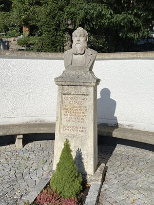 Bild vergrößern: Auf einem steinernen Sockel, steht der nachgebildete Kopf von Konrad Max Kunz.