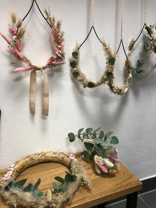 Bild vergr&ouml;&szlig;ern: Verschiedene Trockenblumen sind um einen Ring / Kranz gebunden