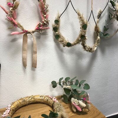Verschiedene Trockenblumen sind um einen Ring / Kranz gebunden