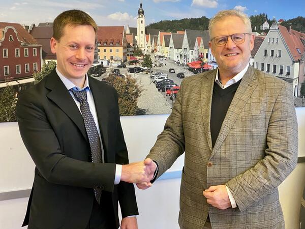Zwei Männer begrüßen sich mit Handschlag.