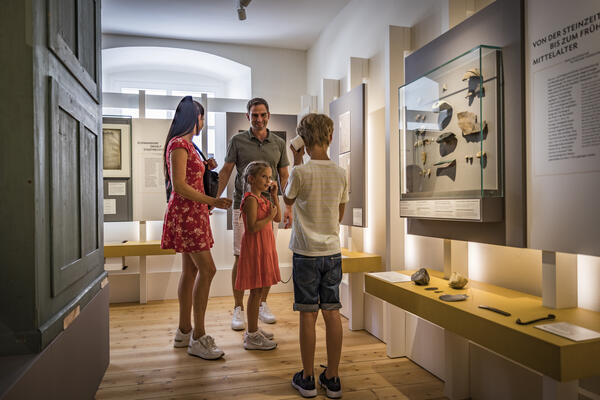 Bild vergrößern: Auf dem Foto sind vier Personen zu sehen. Eine Frau, ein Mann, ein Junge und ein Mdchen, dass vor einem Ausstellungsstck im Stadtmuseum steht.