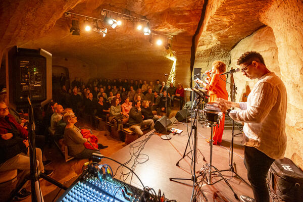 Bild vergr&ouml;&szlig;ern: Seitlicher Blick auf die B&uuml;hne des Kulturkellers in Schwandorf. Darauf zu sehen ist in rotem Anzug die S&auml;ngerin Yeni Toro mit ihrer Band Habana Son.