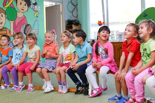 Kinder sitzen in einer Reihe.