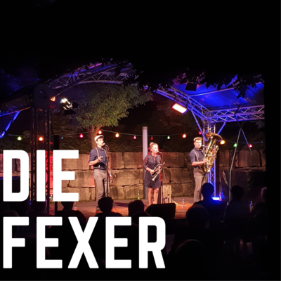 Bild vergrößern: Der Bandname "Die Fexer" ist in weißen Blockbuchstaben auf dem Foto abgedruckt. Im Hintergrund ist die Musikgruppe auf der Open-Air Bühne des Kultursommer 2021 zu sehn.