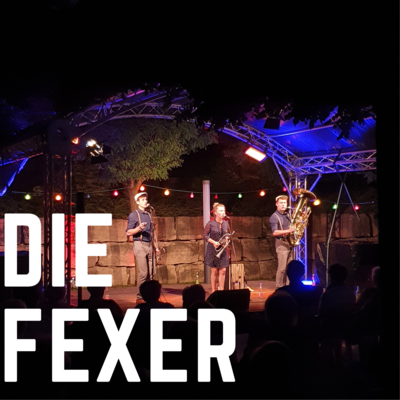 Bild vergrößern: Der Bandname "Die Fexer" ist in weien Blockbuchstaben auf dem Foto abgedruckt. Im Hintergrund ist die Musikgruppe auf der Open-Air Bhne des Kultursommer 2021 zu sehn.