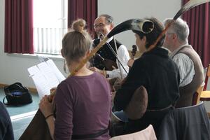 Bild vergrößern: Vier Menschen musizieren mit traditionellen Musikinstrumenten