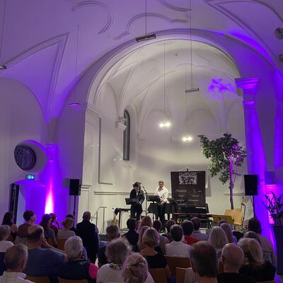 Das Publikum in der Schwandorfer Spitalkirche lauscht dem Duo "WortesKlang" bestehend aus Michael Braun und Michael Chwatal bei der szenischen Rezitation eines Gedichts.