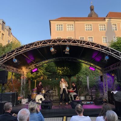 Die Italo-Pop Sängerin Luca Vasta mit ihrer Band auf der Bühne des Schwandorfer Kultursommers im Spitalgarten 2024.