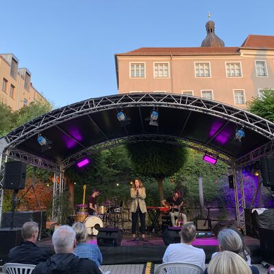 Die Italo-Pop Sängerin Luca Vasta mit ihrer Band auf der Bühne des Schwandorfer Kultursommers im Spitalgarten 2024.
