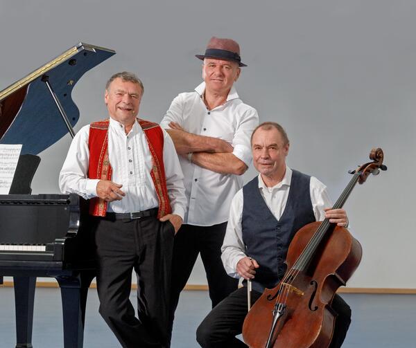 Drei Männer mit einem Klavier und einem Cello.