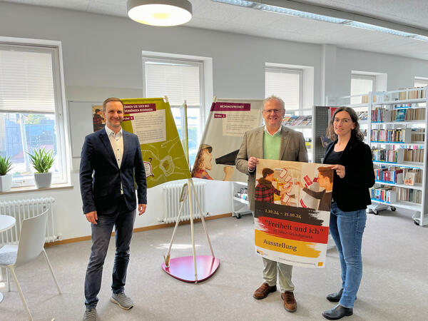Bild vergrößern: Zwei Mnner und eine Frau bei einer Ausstellung.