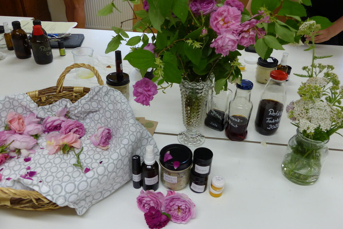 Aufnahme von einem Tisch mit verschiedenen Blumen, Kräutern und Fläschchen