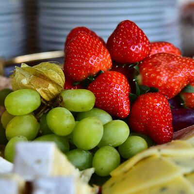 Nahaufnahme von Trauben, Erdbeeren, Physalis und Käse.