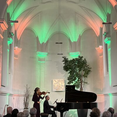 Bild vergrößern: Der Pianist Christian Seibert und die Violinistin Jung-Won Seibert-Oh spielen auf ihren Instrumenten auf der Bühne der Spitalkirche.