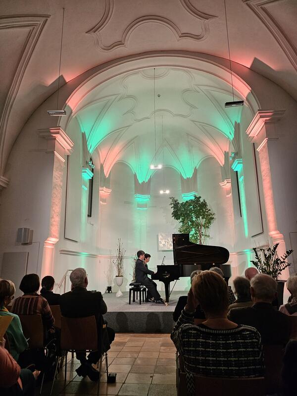 Bild vergrößern: Die beiden Pianisten Junko Tsuji und Hironobu Fuchiwaki sitzen dem Flügel auf der Bühne der Spitalkirche.