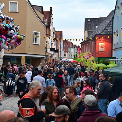 Bild vergrößern: Schwandorfer Bürgerfest 2025. Blick vom Marktplatz in die Friedrich-Ebert-Straße. Viele Menschen sind auf den Straßen, links sieht man einen Strauß bunter Helium-Ballons.