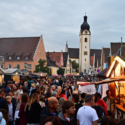 Bild vergrößern: Schwandorfer Bürgerfest 2025. Blick auf den Schwandorfer Marktplatz. Viele Menschen tummeln sich zwischen diversen Verkaufsständen.