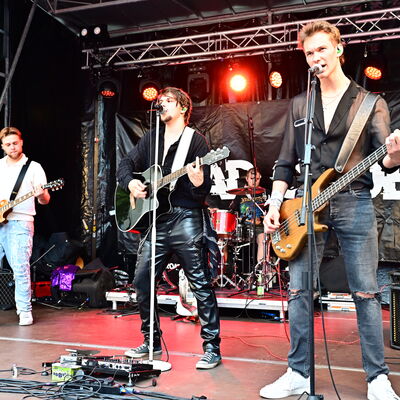 Bild vergrößern: Die drei jungen Musiker der Band Road Crue stehen mit ihren Gitarren auf der Bühne.
