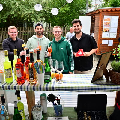 Bild vergrößern: Die vier Verkäufer des Spritz Standes des Verein "Spendenlike" posieren vor ihrem Stand.