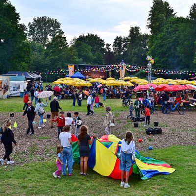 Bild vergrößern: Blick auf den Festplatz im Stadtpark. Im Vordergrund spielen Kinder mit verschiedenen Spielgeräten.