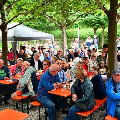 Bild vergrößern: Viele Menschen sitzen an Biertischen im Spitalgarten.