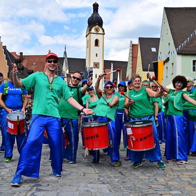 Bild vergrößern: Die Trommelgruppe Sarara spielt auf dem Schwandorfer Marktplatz. Sie tragen alle blaue Hosen und Grüne Tshirts.
