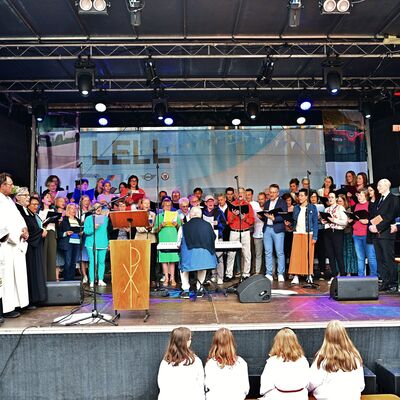 Bild vergrößern: Der Bürgerfest-Chor singt während des ökumenischen Gottesdienstes auf der Bühne am Marktplatz.
