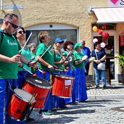 Bild vergrößern: Die Trommelgruppe Sarará zieht durch die Straßen Schwandorfs. Sie tragen grüne Tshirts und blaue Hosen.