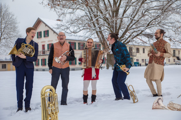 Bild vergrößern: Bandfoto der Unterbiberger Hofmusik. Alle fünf Musiker stehen mit ihren Instrumenten im Schnee