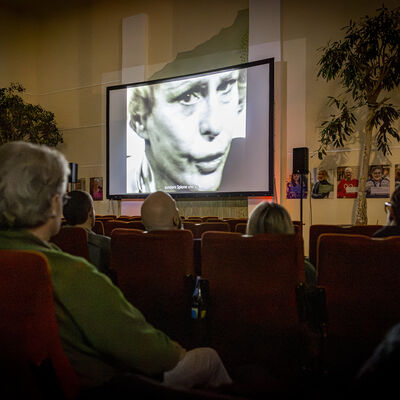 Das Publikum schaut auf die Leinwand, auf der ein Film abgespielt wird.